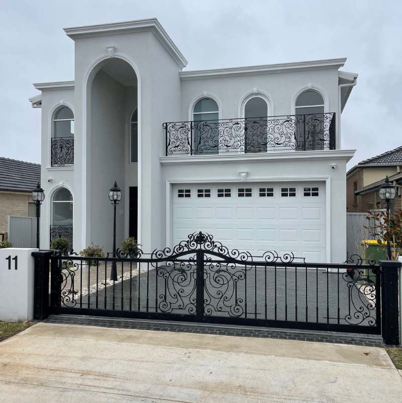 A recently repaired black automatic gate in front of a white two-story house in Sydney